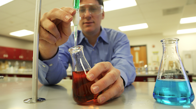 two male students looking through a microscope