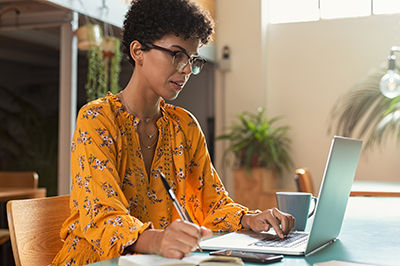 woman-yellow-shirt-on-latop-writing