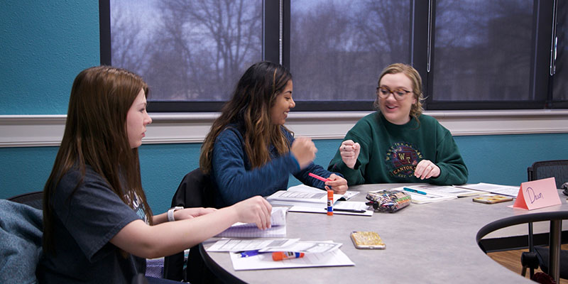 Students engaged around a table