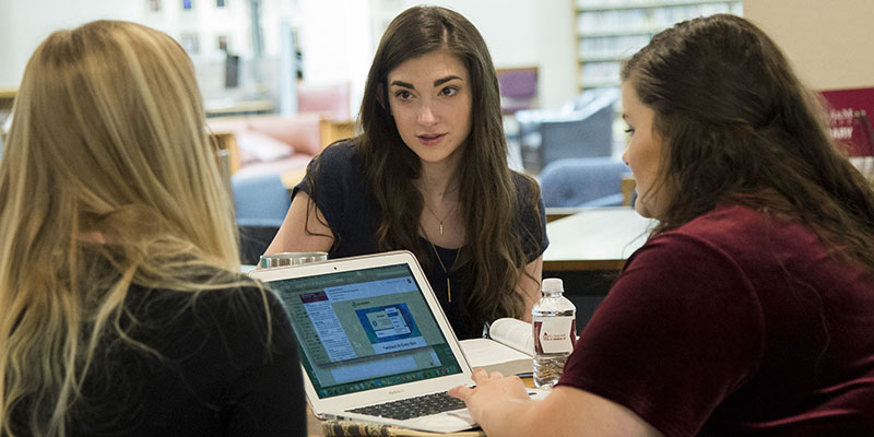 students around a laptop