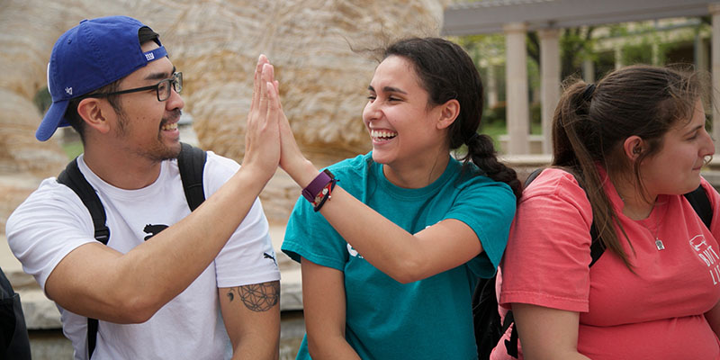 students holding up buff hand sign