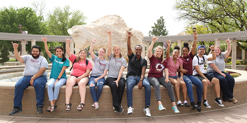 Students around fountain giving the Buff hand signal