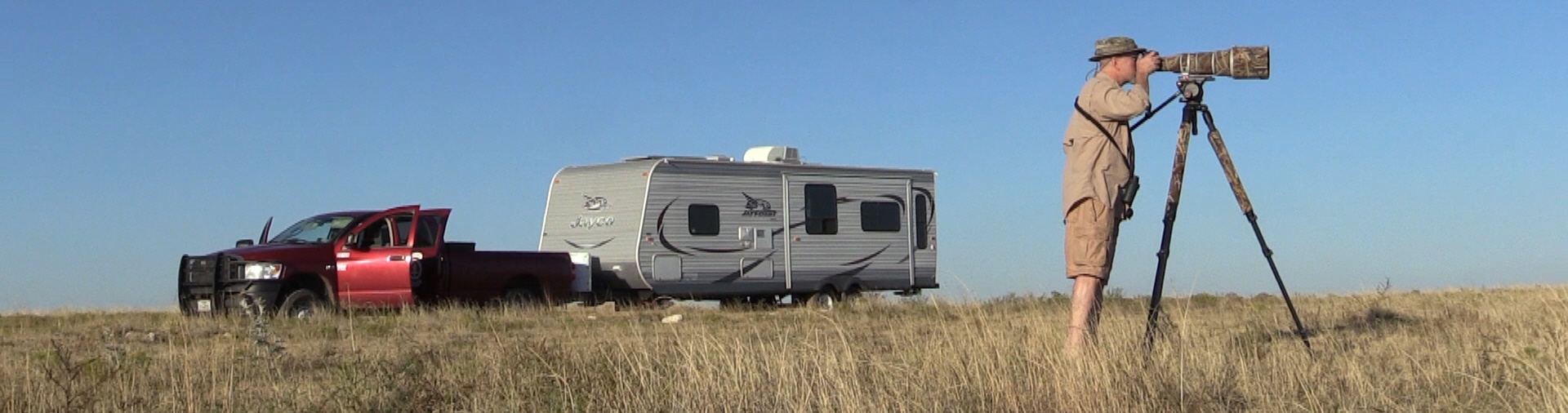 Matlack filming swift foxes, truck and travel trailer in background